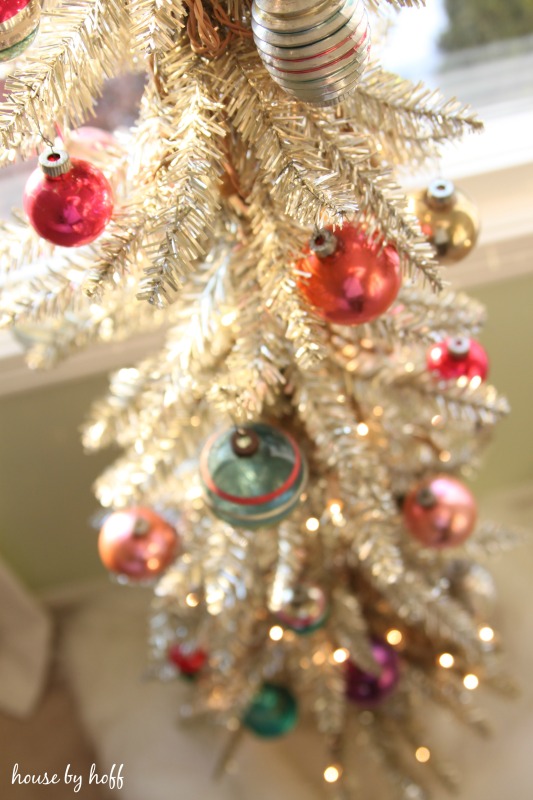 Red, green, blue and gold ornaments on tree.