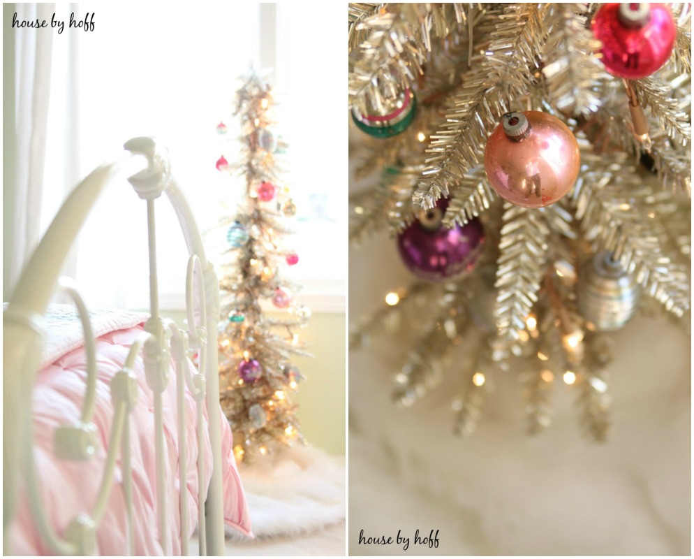 Small Christmas tree in corner of the bedroom with white bed and pink blankets on the bed.