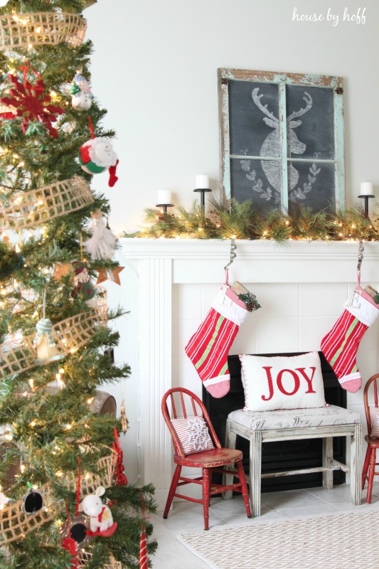 A large Christmas tree is in the corner by the fireplace in the living room.