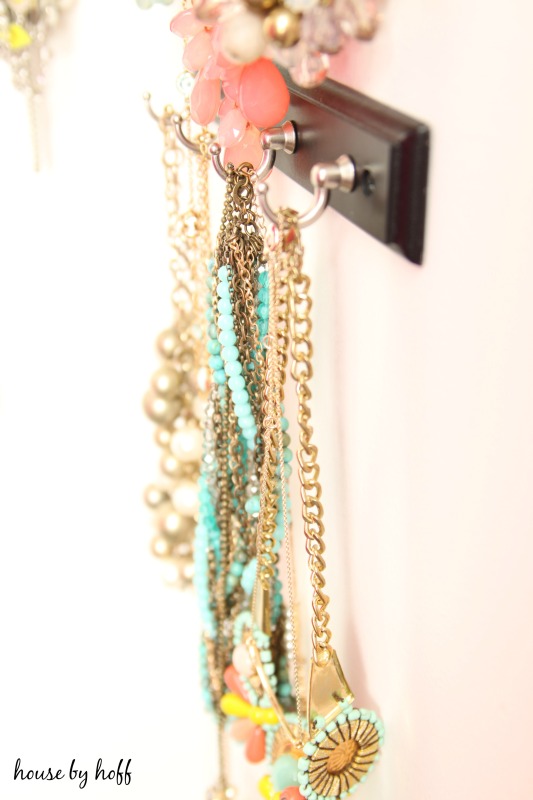 Side view of necklaces hanging on hooks.