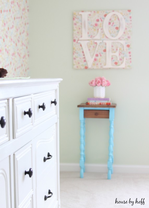 Little blue side table in girl's bedroom.