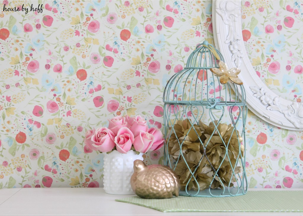 Wire bird cages filled with dried flowers, also pink flowers on the dresser.