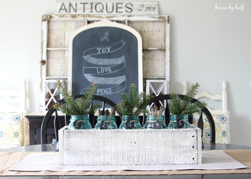 Mason jars filled with evergreen clippings on the dining room table.