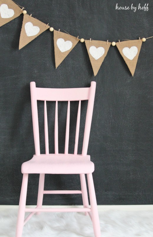 A pink chair, pennant, and chalkboard.