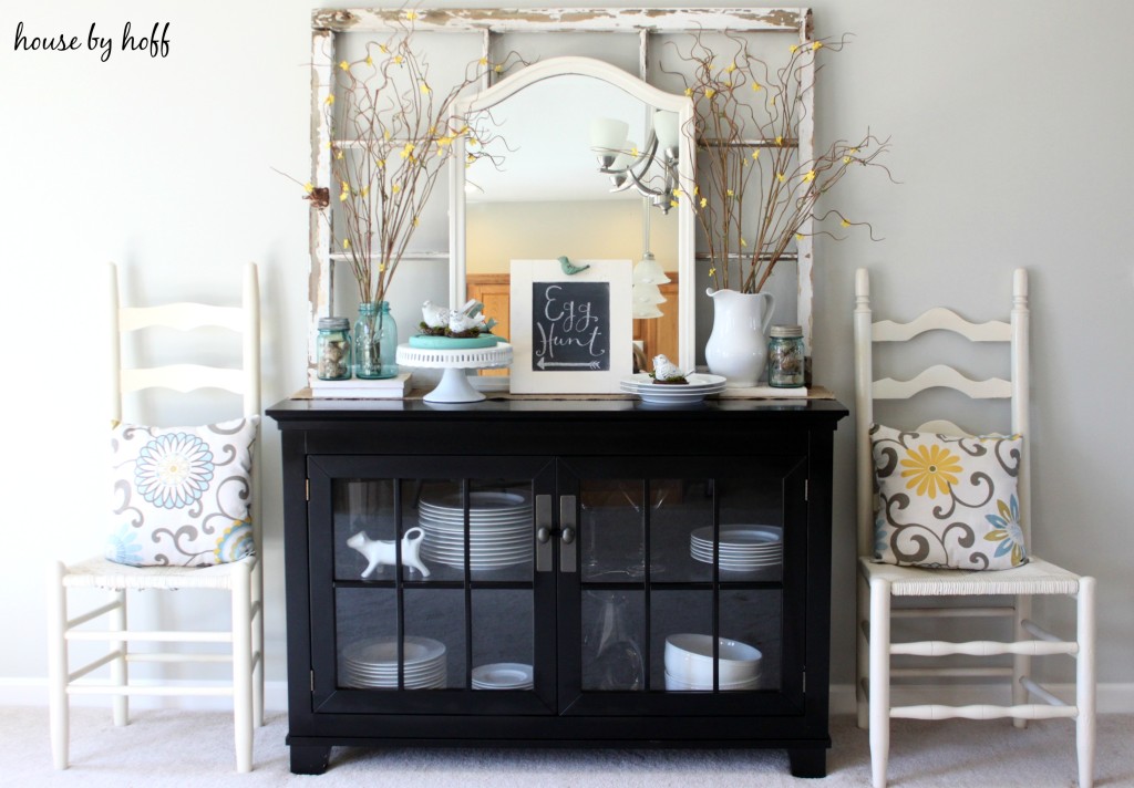 A hutch with a mirror on top of it and a wooden window frame behind the mirror.