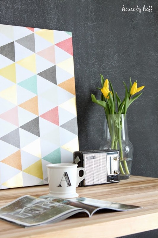 The desk completed with a vase filled with yellow flowers, a radio, a mug and a magazine on the desk.