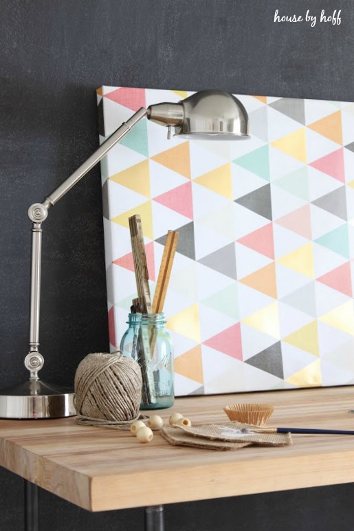 A stainless steel desk lamp, and spool of twine on desk.