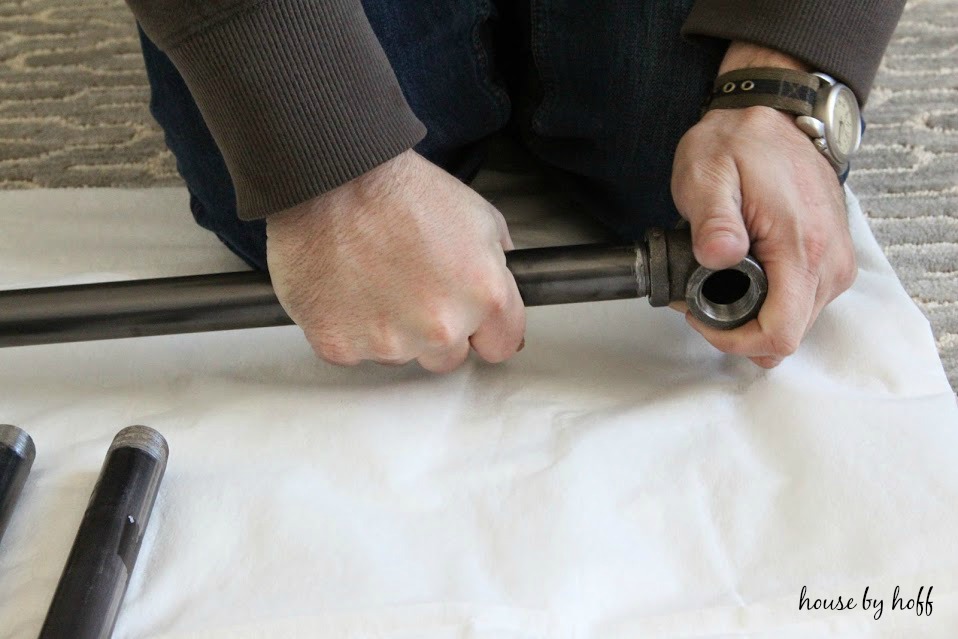 A man's hands fitting the pipes together.