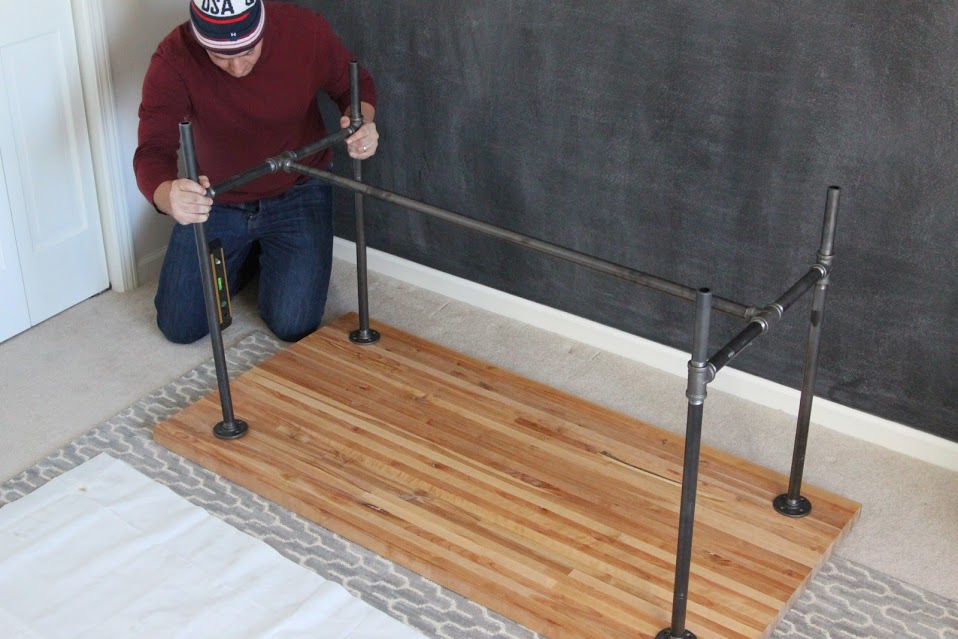 Attaching the top butcher block wood to the legs of the table.