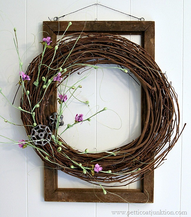 A grapevine wreath with small purple flowers.