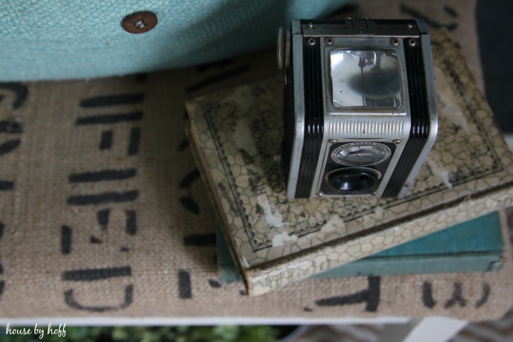 A vintage camera on top of the piano bench.