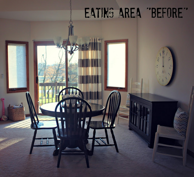 Dark brown table and chairs and a light fixture above it.