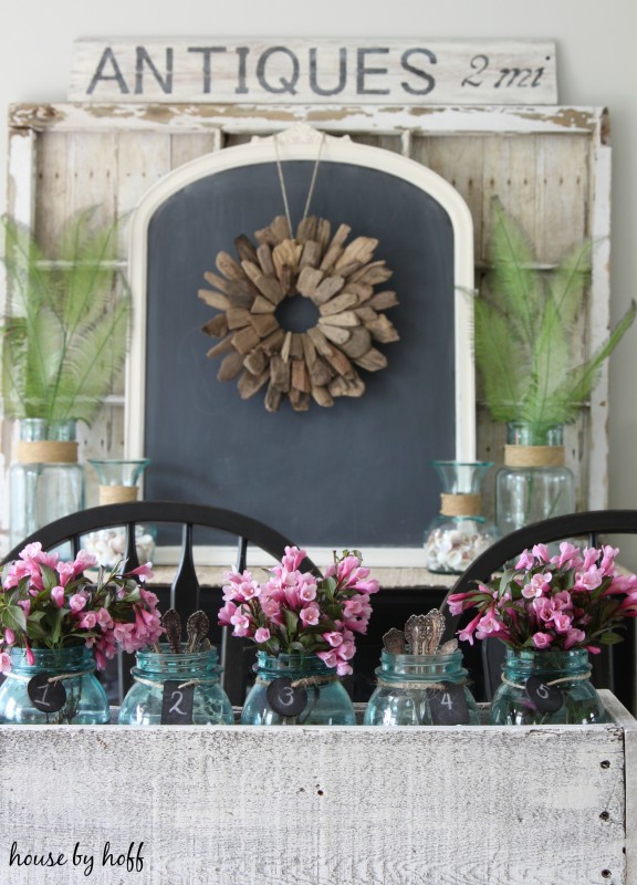 Pink flowers in jars on table.