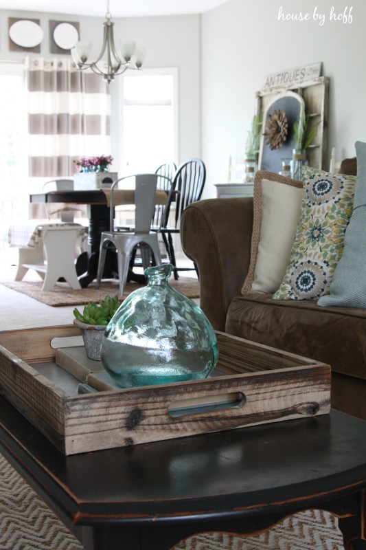 Coffee table in living room with glass jar on it.