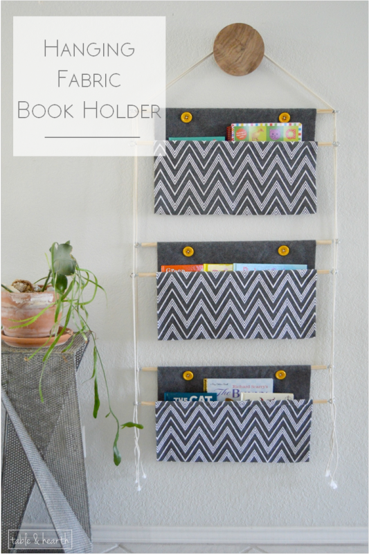 A fabric book holder hanging on a wall.