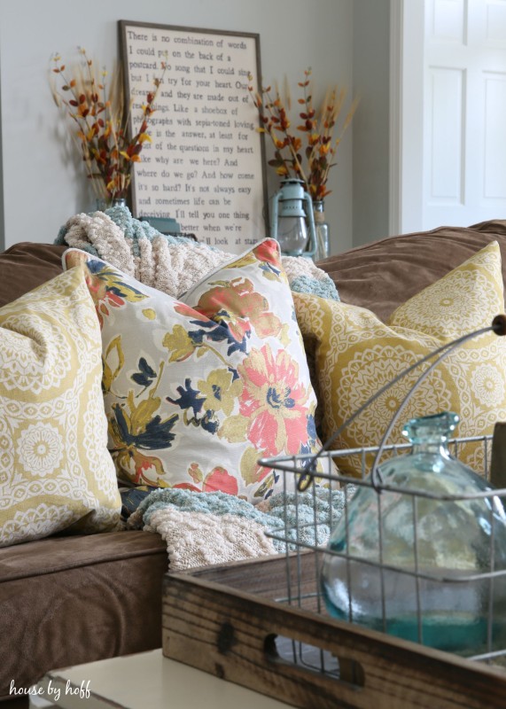 Brown suede couch with pillows on it.