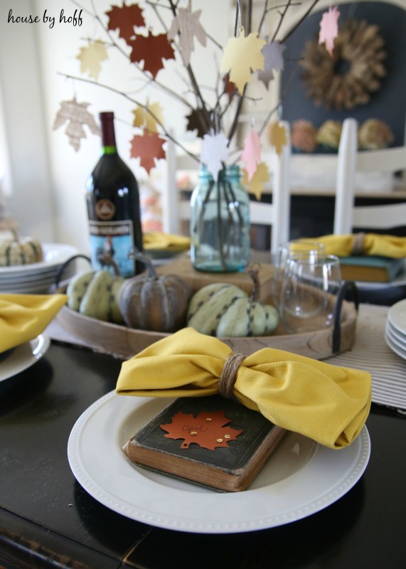 Antique books with cloth napkins on table setting.