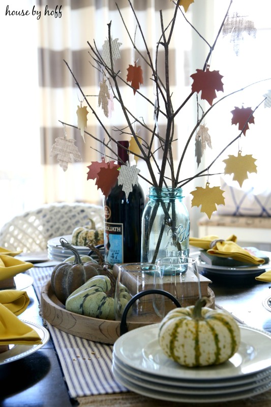 Green and white pumpkins on white plates on table.