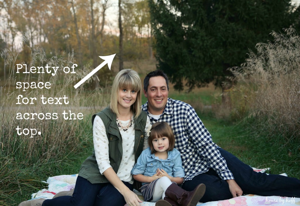 A family sitting on a blanket on the grass.