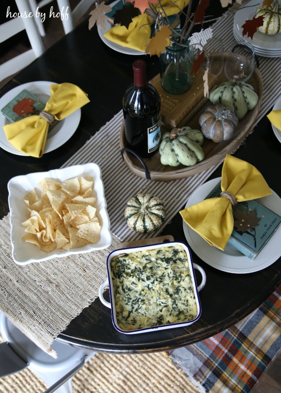 Aerial view of Thanksgiving table setting with spinach dip, wine, and chips.