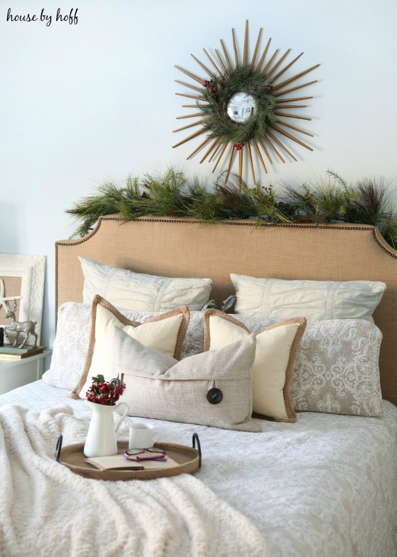 Fresh green garland on top of the headboard in the bedroom.