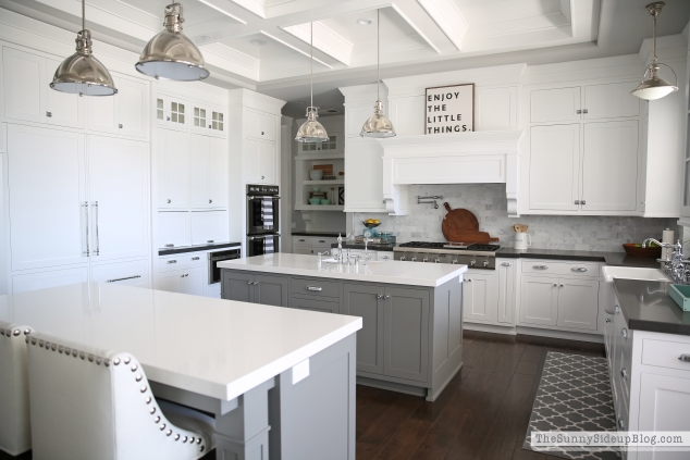 White kitchen cabinets with a gray island.