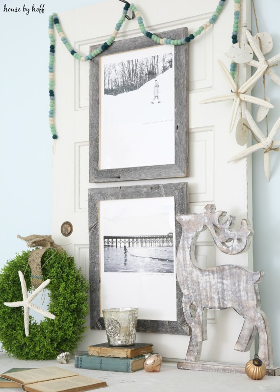 A wooden deer, starfish, a wreath and Minted pictures on the wall.