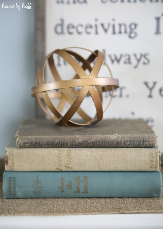 Gold geometric ball on top of vintage books.