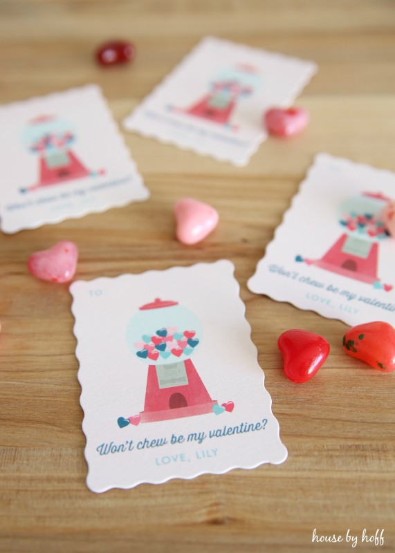 Valentines Day cards on the table with little heart candies beside them.