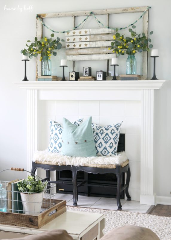 The fireplace with flowers on mantel and candles.