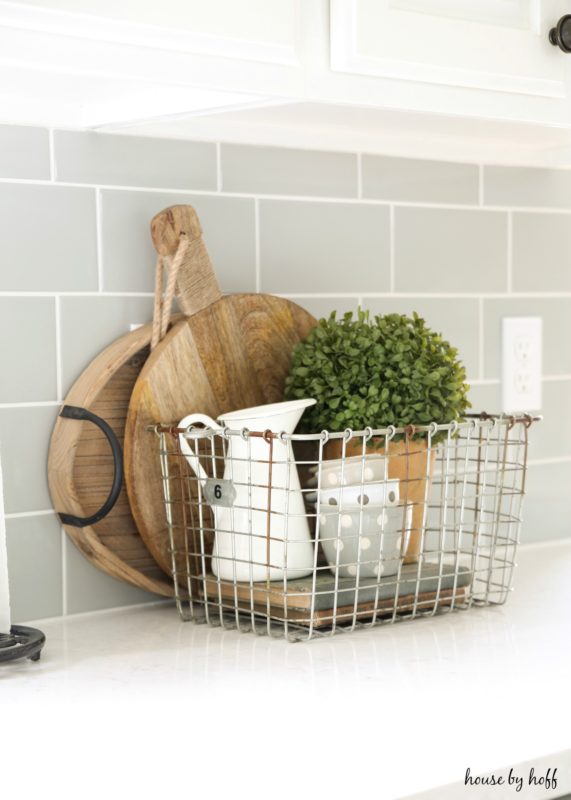 Cutting boards behind wire basket on counter.