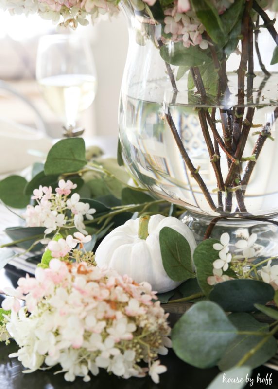 White pumpkin and green leaves on table.