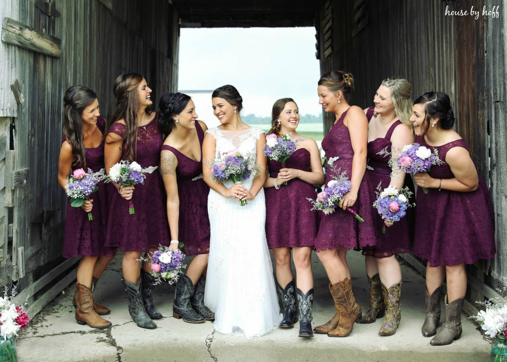 All the bridesmaids in plum dresses beside the bride.