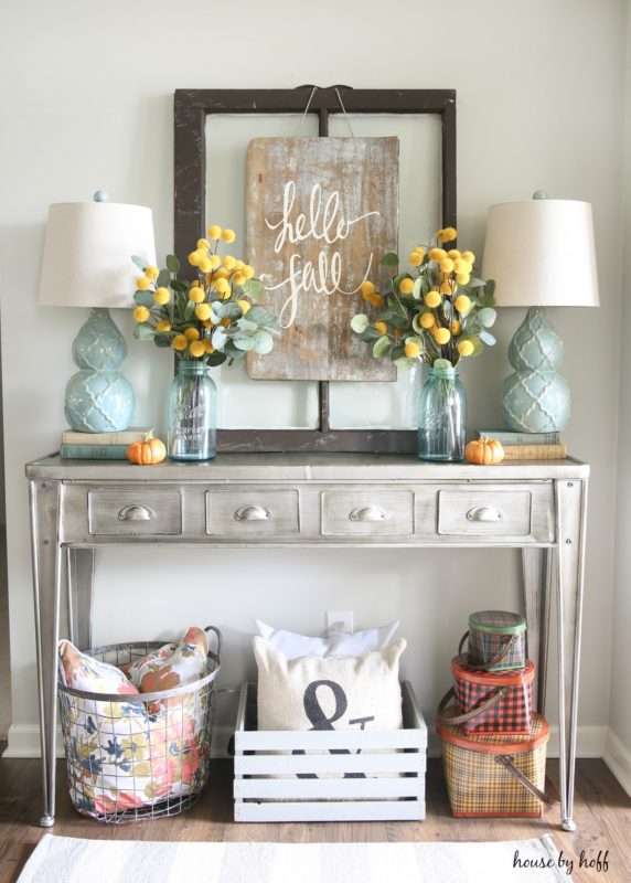 Hello fall decor sign hanging up in front of distressed desk.