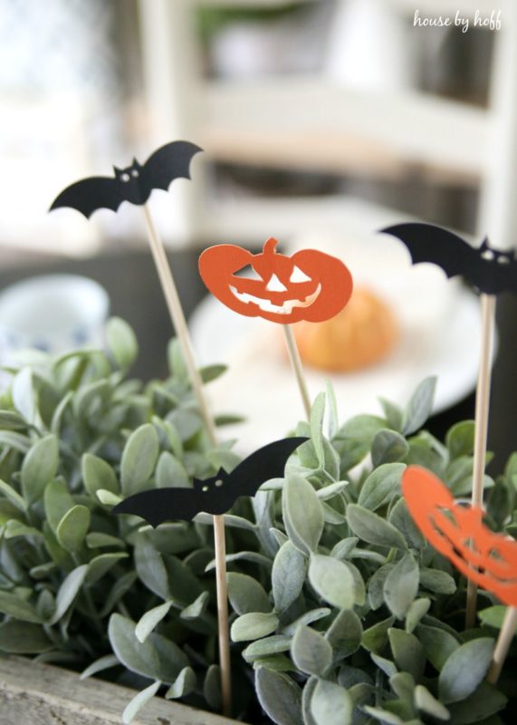 Bats and pumpkins in the succulents on the table.