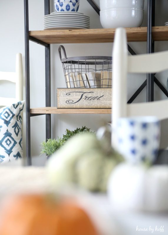 Sign saying treat on wooden and metal shelf.