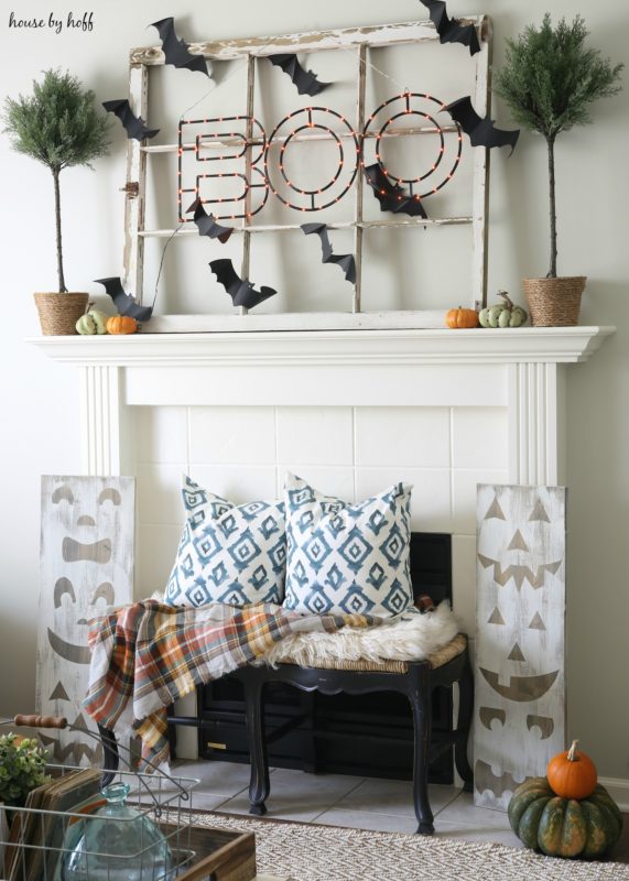 Halloween mantel with Boo sign lit up and black bats.