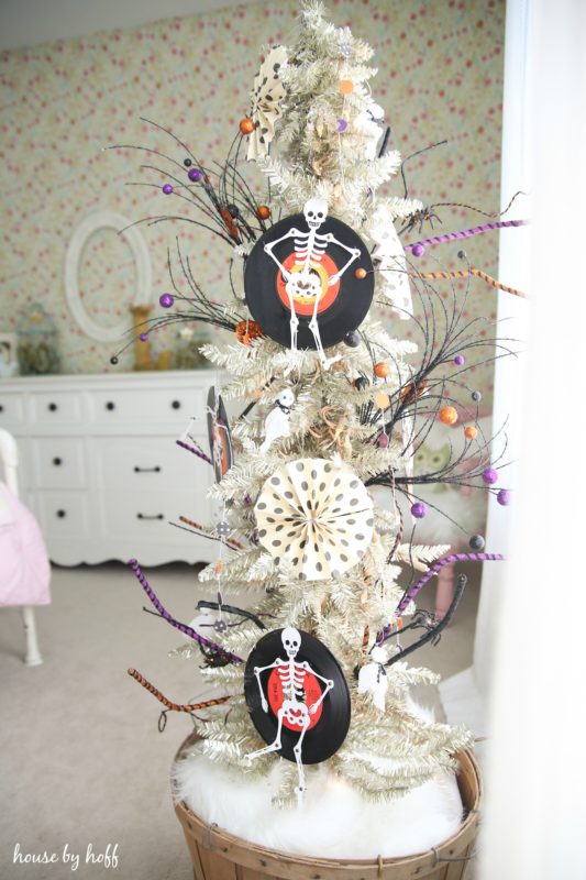 White artificial tree with skeletons and feather.