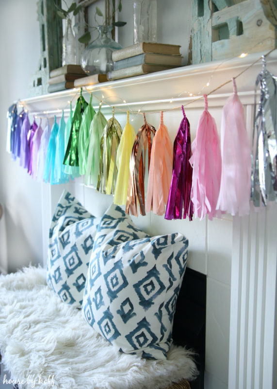 A Colorful banner over the fireplace with pillows in front of the mantel.