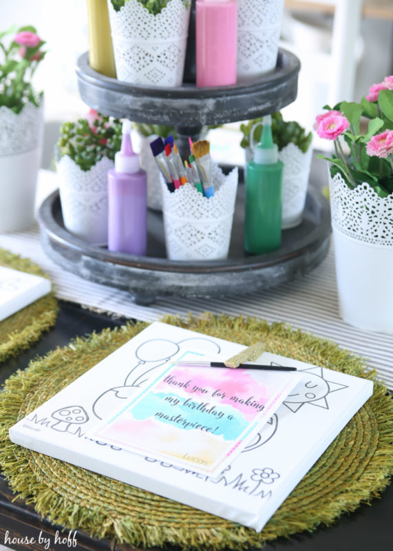 Paint brushes on the table with purple, green and pink paint.