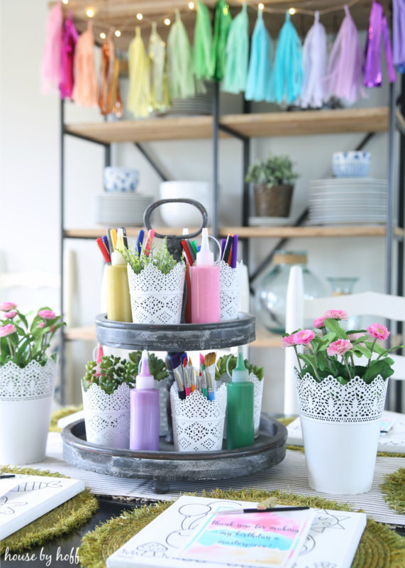 Open shelving behind table, with colourful garland.