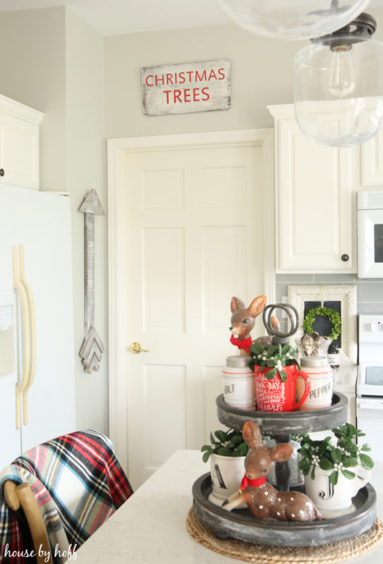 DIY Holiday Sign that says Christmas trees hanging above the door in the kitchen.