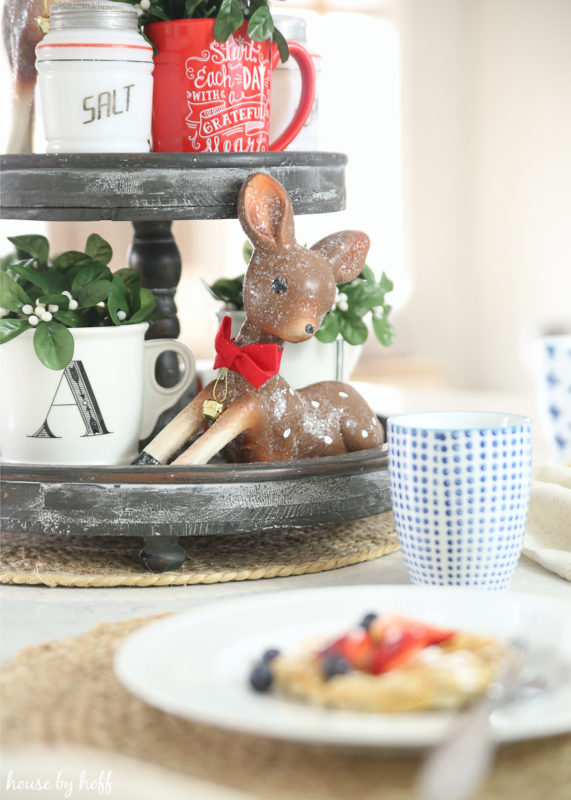 Up close picture of the little deer on the tray with a red bow around its neck.