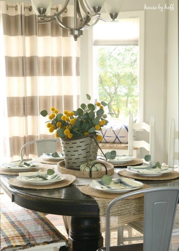 Dining room with brown and white striped drapes half open.