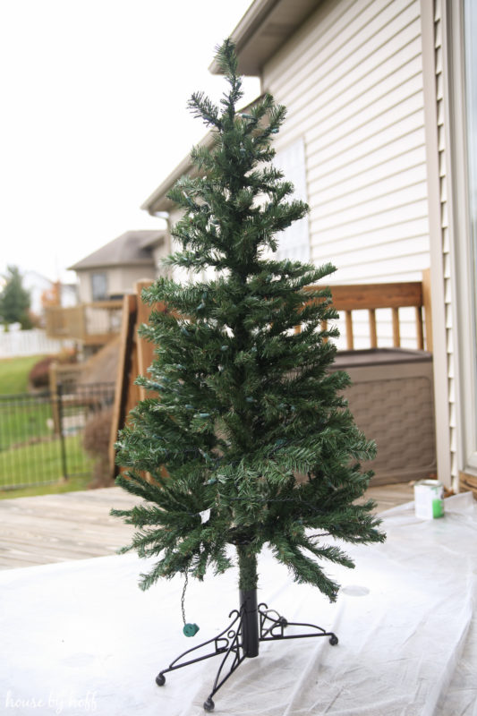 A large plain Christmas tree outside on the deck.