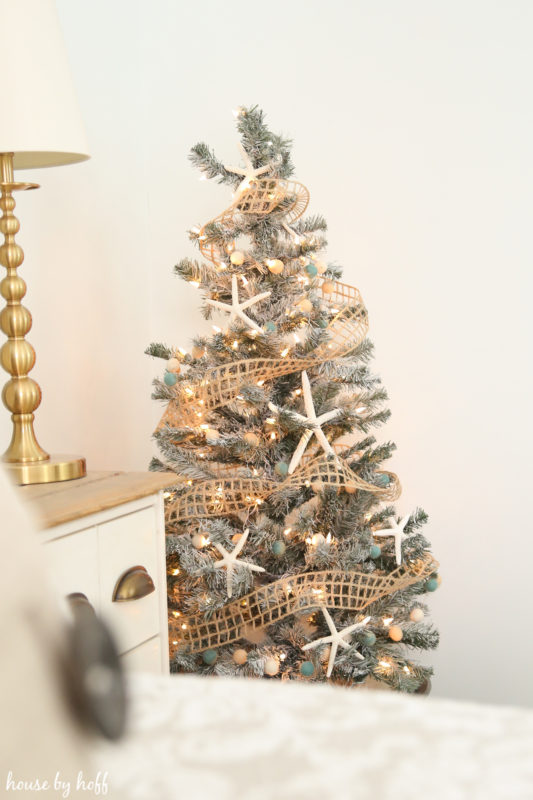 A gold lamp and Christmas tree in living room.