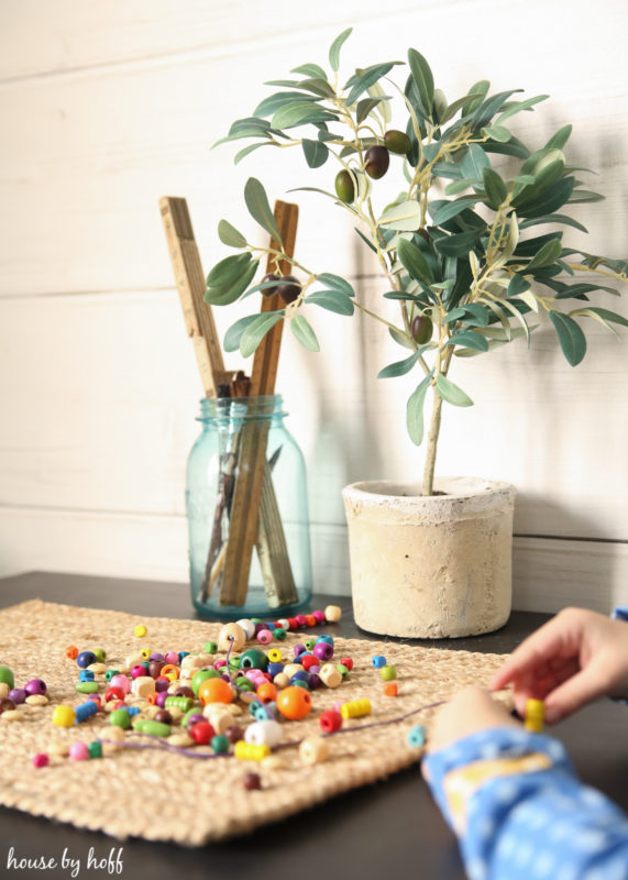 Playing with bright colored beads on the table.