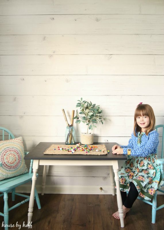 A little girl playing at a small table in the room.