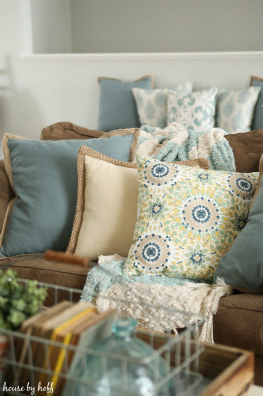 Multi coloured pillows on beige couch.