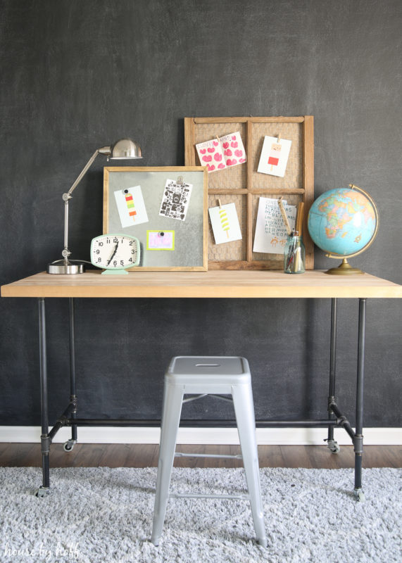 A small desk with a world globe and an area rug under the table.